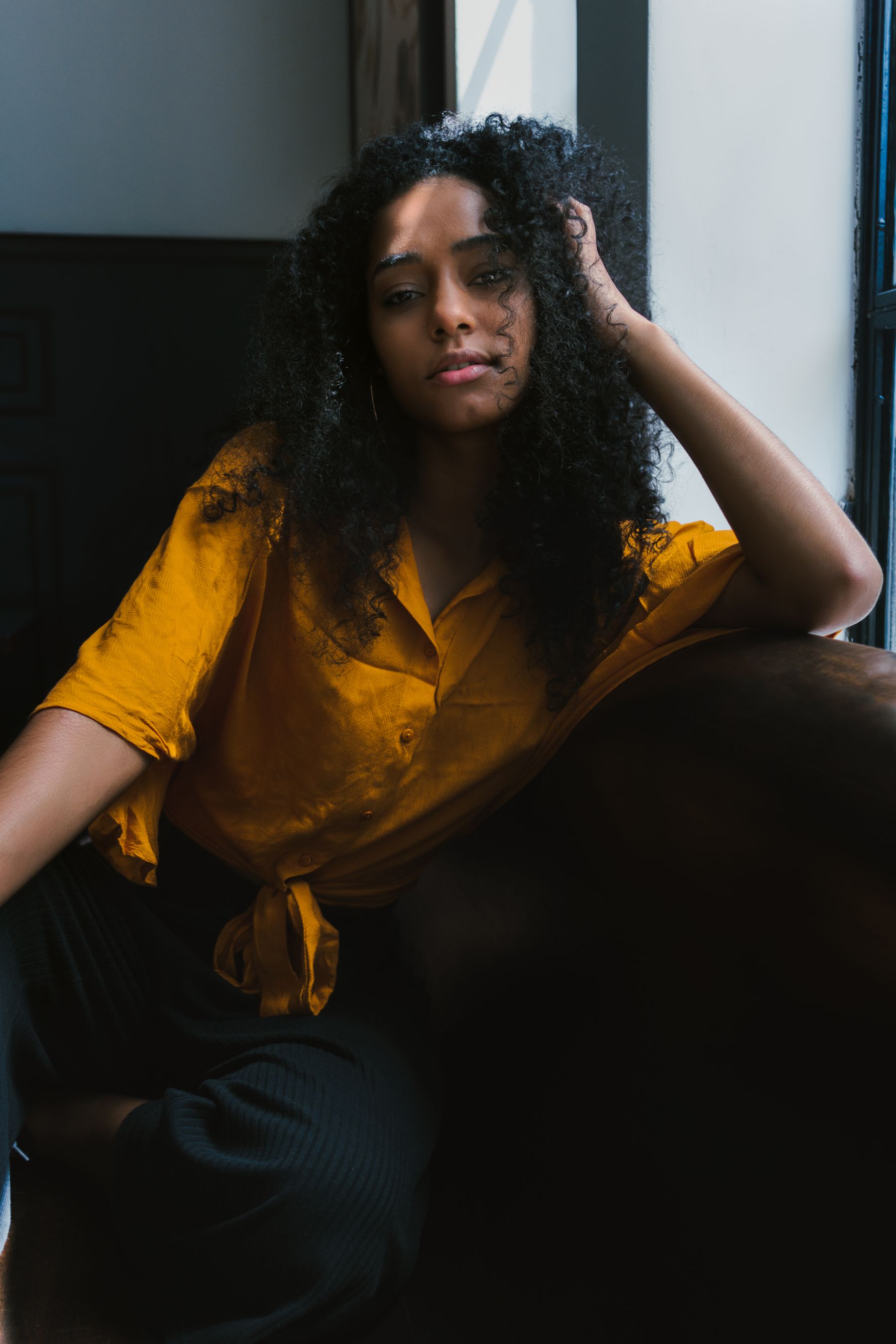 A woman taking a quiet restorative moment beside a window